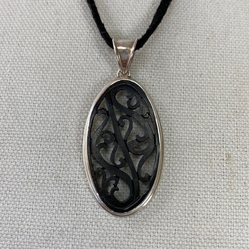 Carved wood pendant 925 on black cord